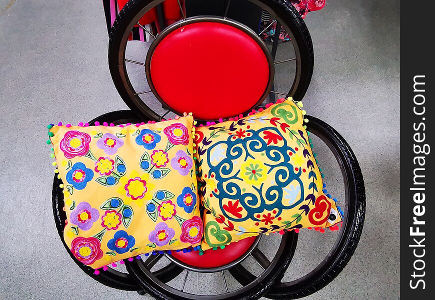 Chair made of bicycle wheels and pillows colorful - red round back.