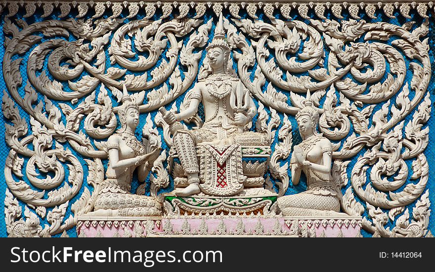 Thai style molding art with blue glass at the wall of temple.