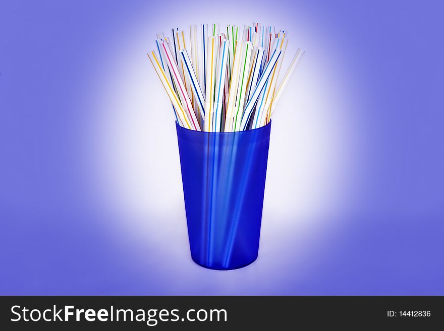 A blue plastic beaker full of colourful drinking straws