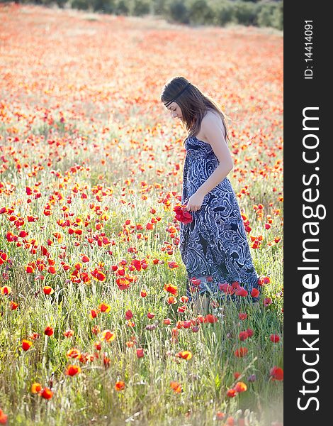 Young candid girl surrounded by poppies. Young candid girl surrounded by poppies.