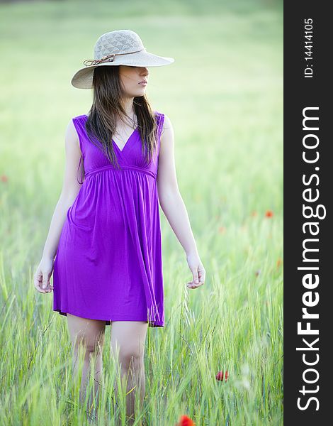 Young girl on field hiding behind her hat. Young girl on field hiding behind her hat.