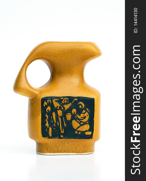 Israeli original ceramic jug of 50-th years in dark yellow tones, decorated by schematic image of household scene. Isolated on white. Israeli original ceramic jug of 50-th years in dark yellow tones, decorated by schematic image of household scene. Isolated on white