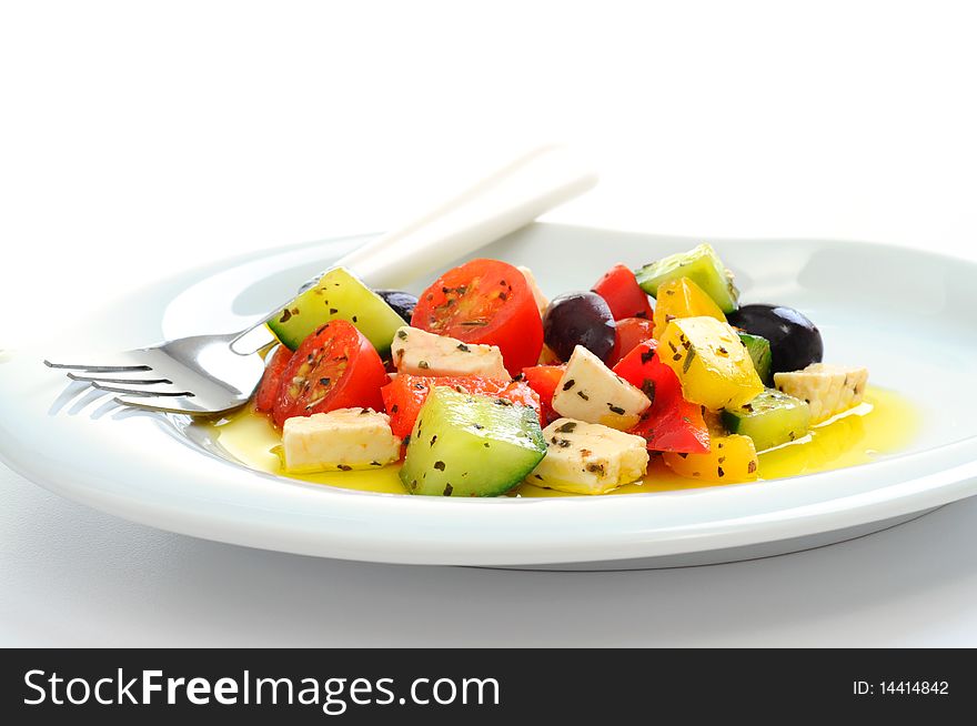 Delicious fresh greek salad on a white background.