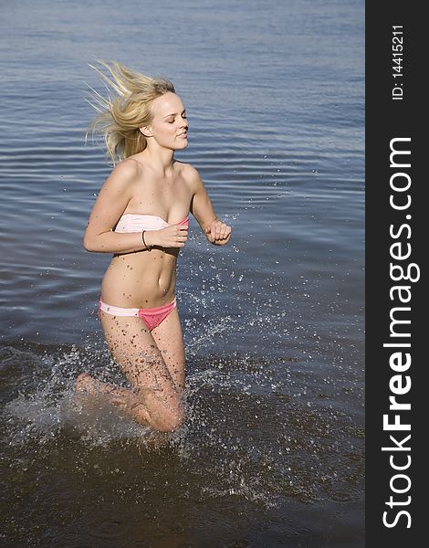 A woman running in the water enjoying the refreshing feel. A woman running in the water enjoying the refreshing feel.