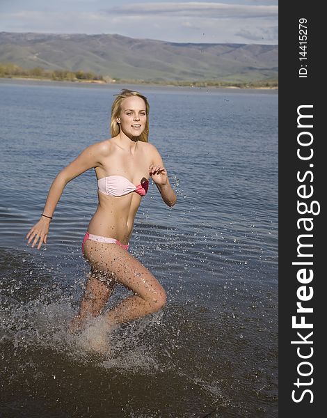 A woman running in the water enjoying the refreshing feel. A woman running in the water enjoying the refreshing feel.