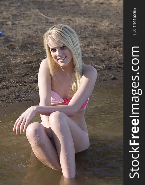 A woman sitting in the water with a happy expression on her face. A woman sitting in the water with a happy expression on her face.