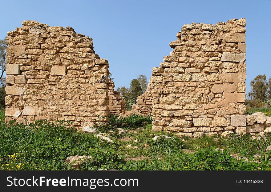 Symmetric ruins of the old stone house among vegetation