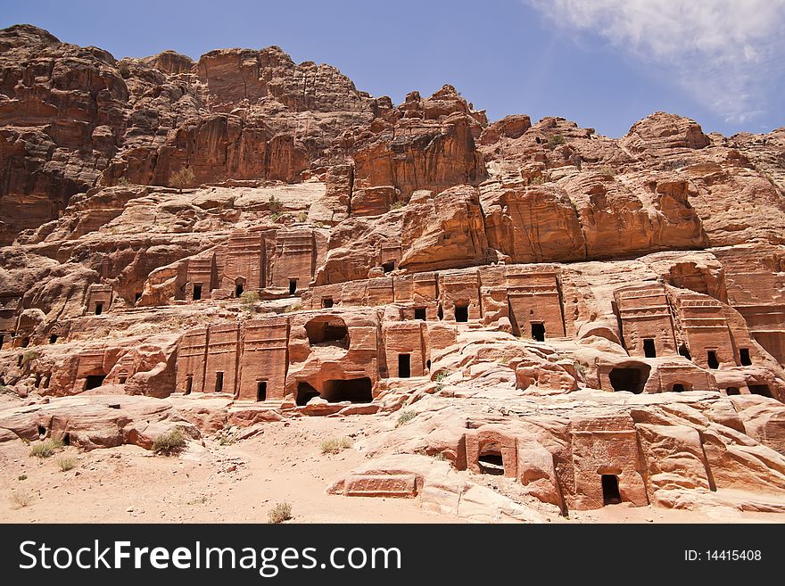 Wide view of large cliff side tomb carved from the beautiful richly-colored sandstone in the ancient city of Petra, Jordan. Wide view of large cliff side tomb carved from the beautiful richly-colored sandstone in the ancient city of Petra, Jordan