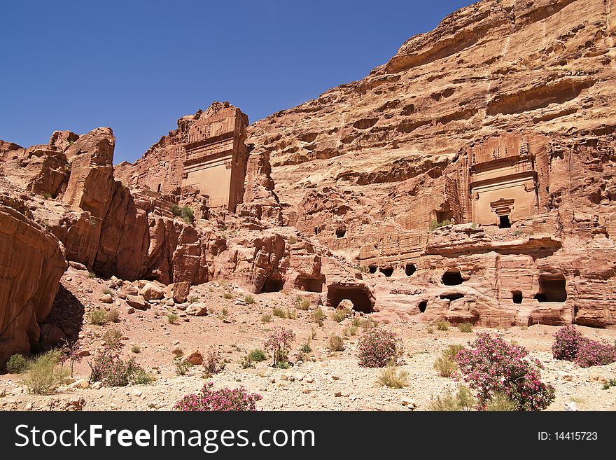 Wide view of large cliff side tomb carved from the beautiful richly-colored sandstone in the ancient city of Petra, Jordan. Wide view of large cliff side tomb carved from the beautiful richly-colored sandstone in the ancient city of Petra, Jordan