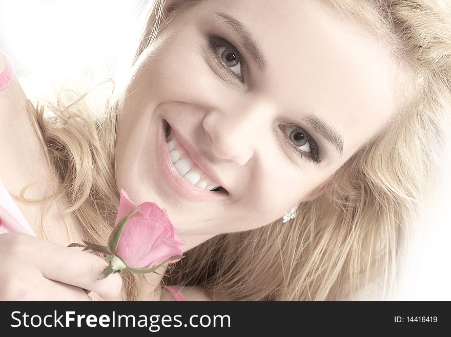 Portrait of a young and attractive blond holding a pink rose. Image isolated on a white background. Portrait of a young and attractive blond holding a pink rose. Image isolated on a white background.