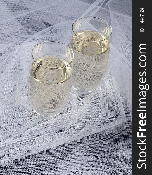 Glasses with champagne and white veil