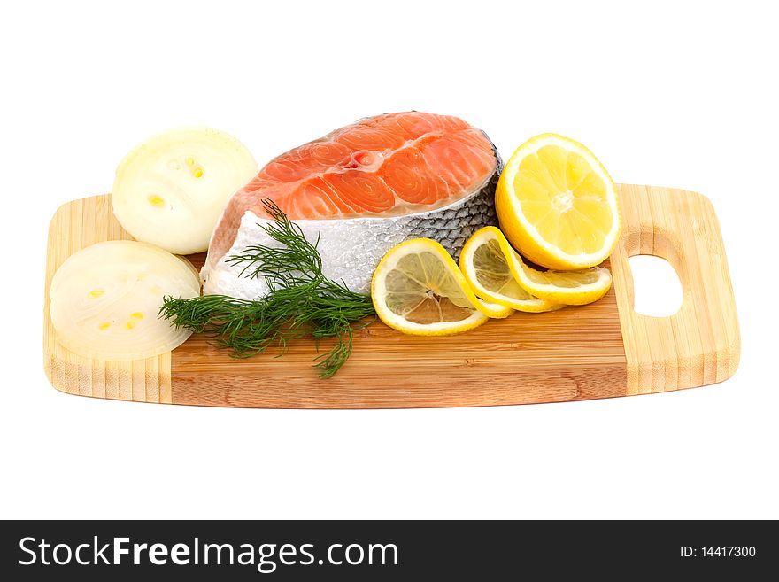 Salmon steak, lemon and onions on a cutting board isolated on white