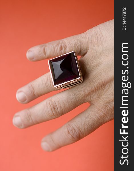 Gemstone ring in the finger of a hand