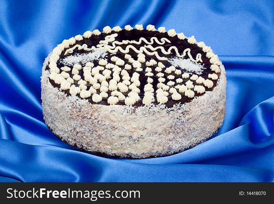 Chocolate coconut cake on a blue satin