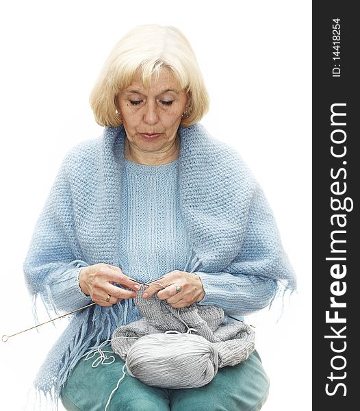 Middle aged woman knitting over white