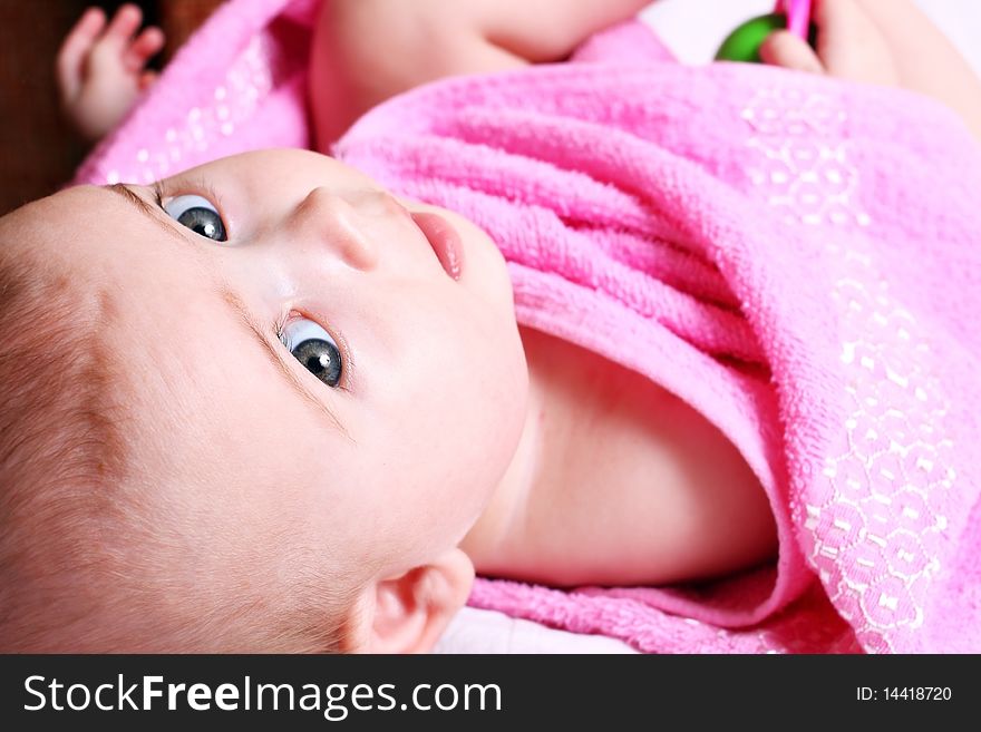 Happy newborn child in a pink towel. Happy newborn child in a pink towel