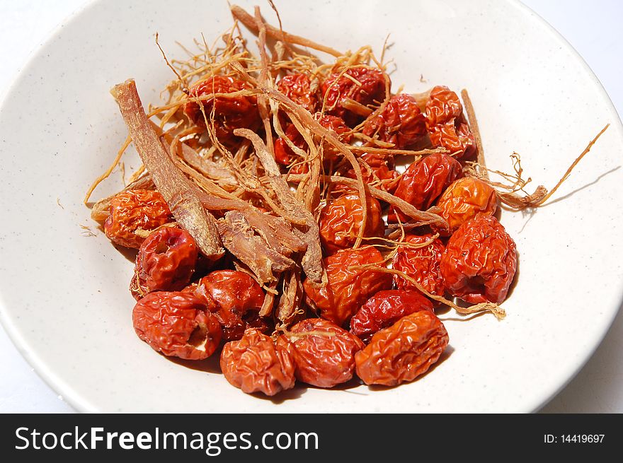Close up of red dates and ginseng on the plate