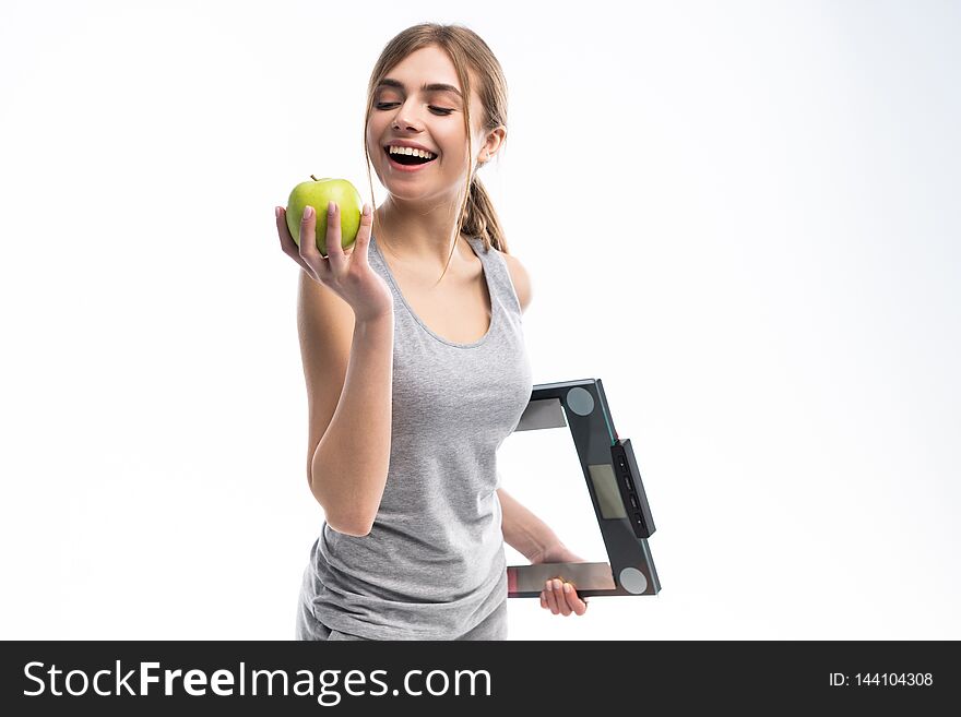 Healthy woman stands with the scales and green apple. Healthy eating concept.