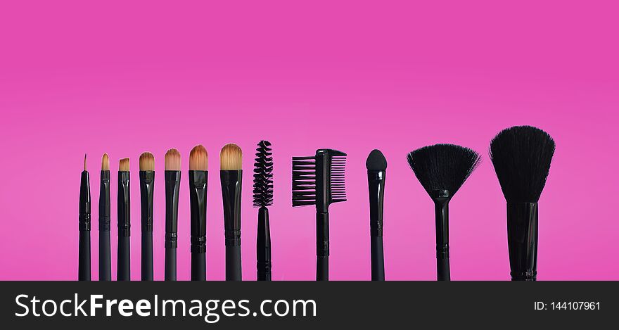 Set of makeup brushes on pink, blue colored composed background, isolated white. Set of makeup brushes on pink, blue colored composed background, isolated white