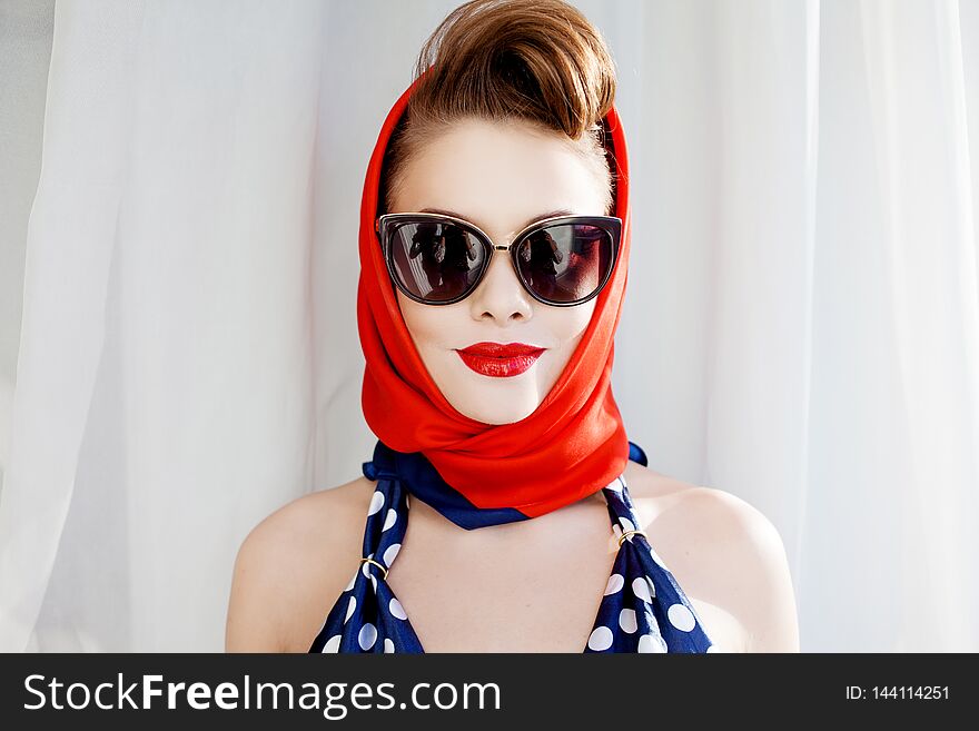 Young beautiful woman with red lipstick and a headscarf.