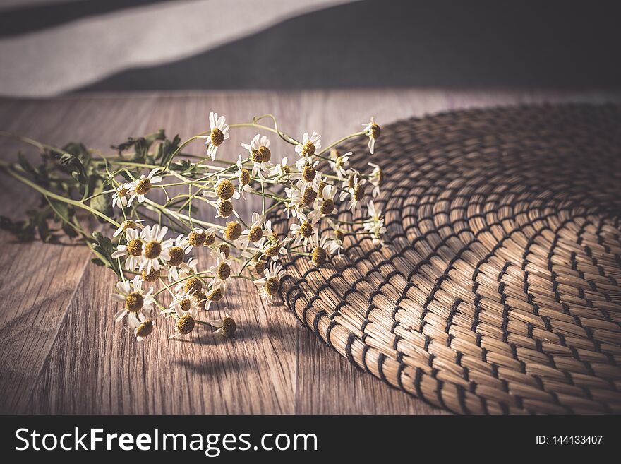 Flat lay toned image of chamomile on straw napkin background shallow depth of field