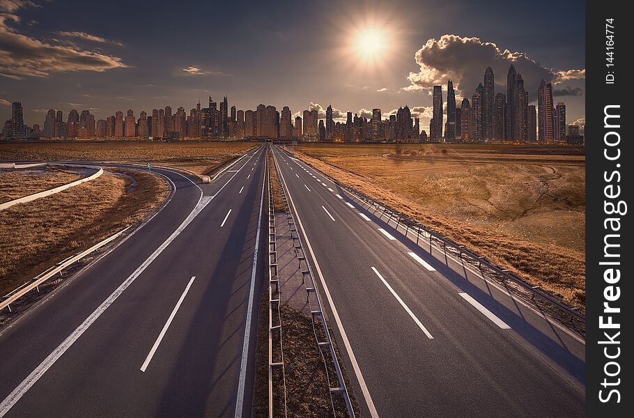 Empty motorway towards the sun and cityscape at beautiful sunset. Empty motorway towards the sun and cityscape at beautiful sunset