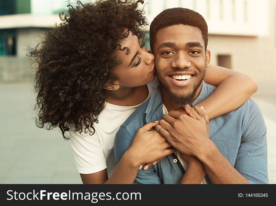 Couple date. Girl hugging boyfriend, walking in city