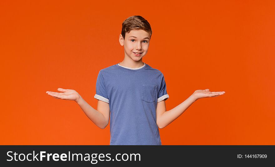 Cute little boy with doubting expression, both palms facing up, orange background with empty space. Cute little boy with doubting expression, both palms facing up, orange background with empty space