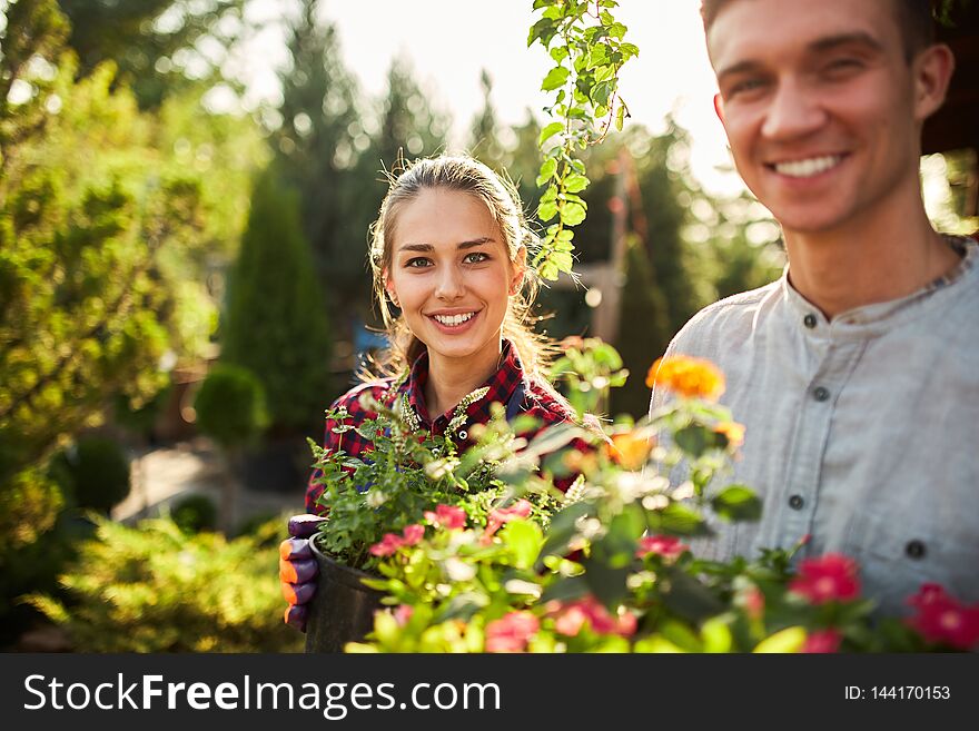 Gardeners Happy Boy And Girl Hold Pots With Plants In Beautiful Gardens On A Warm Sunny Day