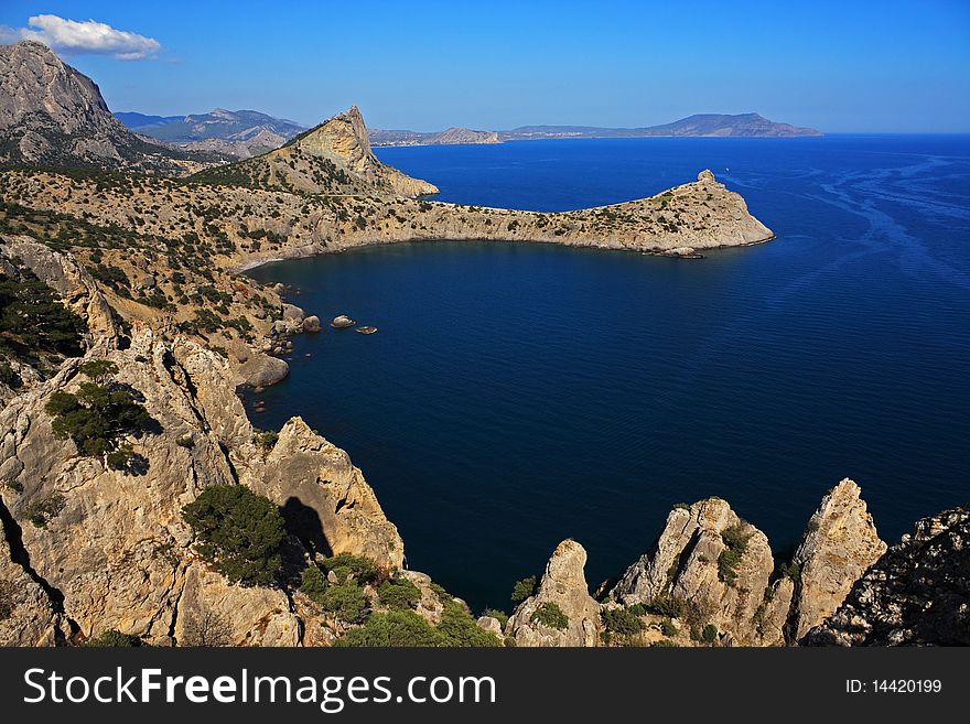 Mountain and sea landscape east of crimea. The mountains and rocks, covered with juniper and pine. Blue sea. Mountain and sea landscape east of crimea. The mountains and rocks, covered with juniper and pine. Blue sea