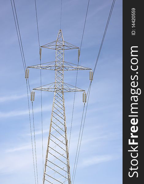 High voltage electricity pylon against blue sky