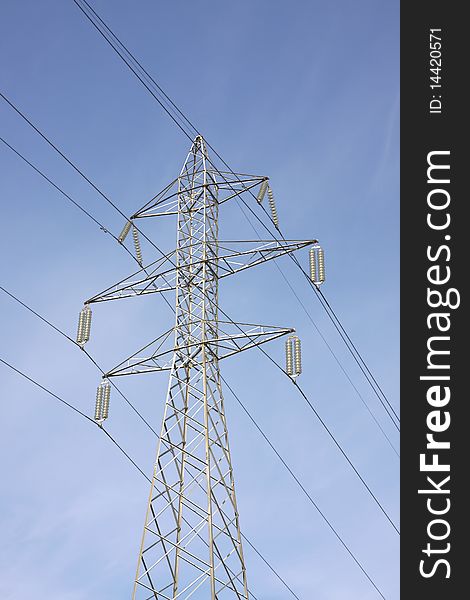 High voltage electricity pylon against blue sky