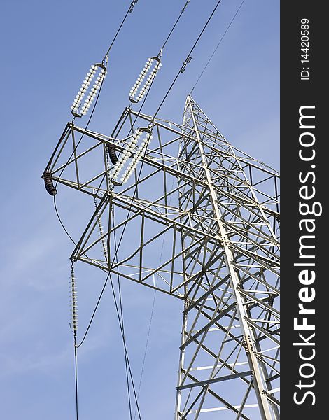 High voltage electricity pylon against blue sky