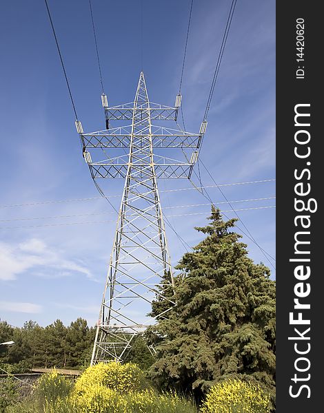High voltage electricity pylon against blue sky