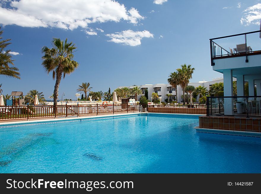 Swimming pool in a hotel with a blue sky background. Swimming pool in a hotel with a blue sky background