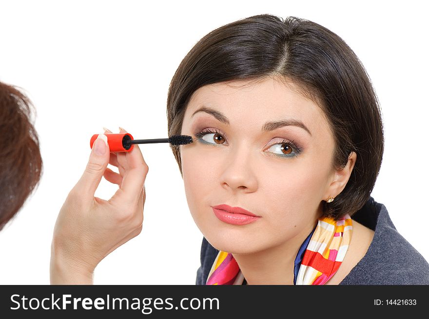 Young brown eyed lady applying mascara using lash brush