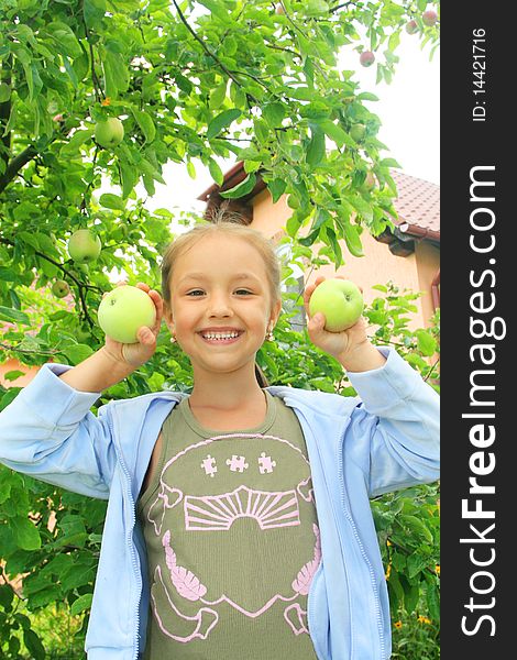 A smiling girl with the apples in the hands. A smiling girl with the apples in the hands