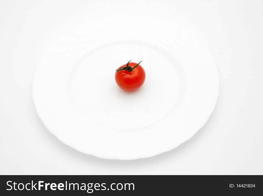 An image of a little red tomato on a plate