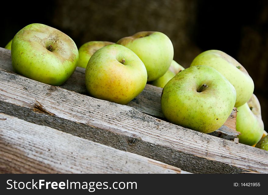 An image of juicy green apples on wooden bars