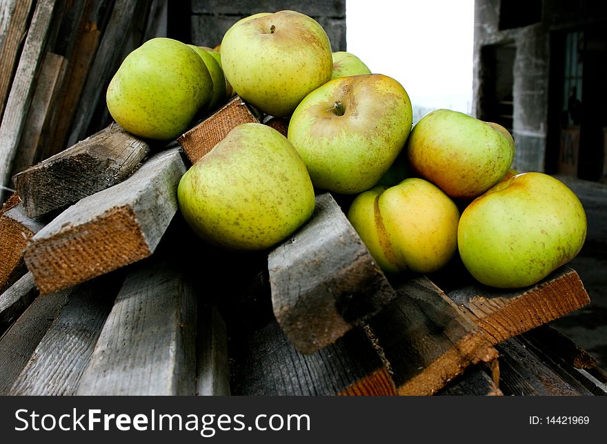 An image of green apples on wooden bars. An image of green apples on wooden bars