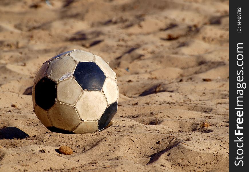 Soccer ball on beach in white and black leather