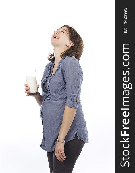 Pregnant woman with glass of milk laughing and enjoying