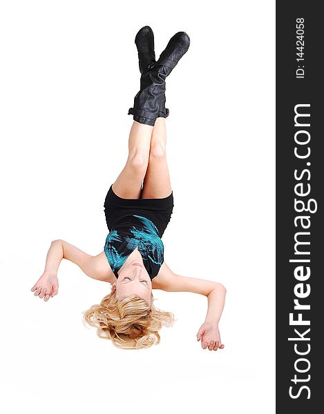 A young blond woman in a blouse and short skirt resting and lying on the floor, holding her nice legs up in black boots, for white background. A young blond woman in a blouse and short skirt resting and lying on the floor, holding her nice legs up in black boots, for white background.