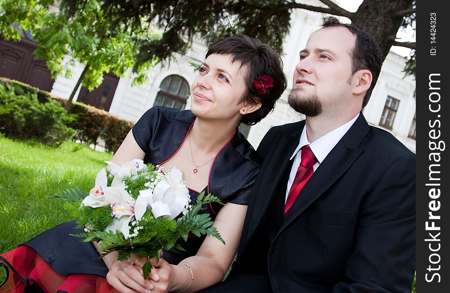 Happy young couple standing below tree