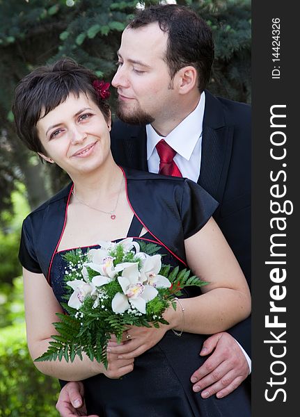 Happy young couple posing - woman with bouquet