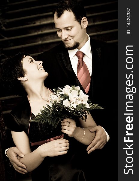 Happy young couple posing - woman with bouquet