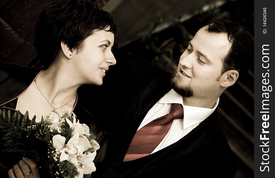 Happy young couple looking at eachother - woman with bouquet