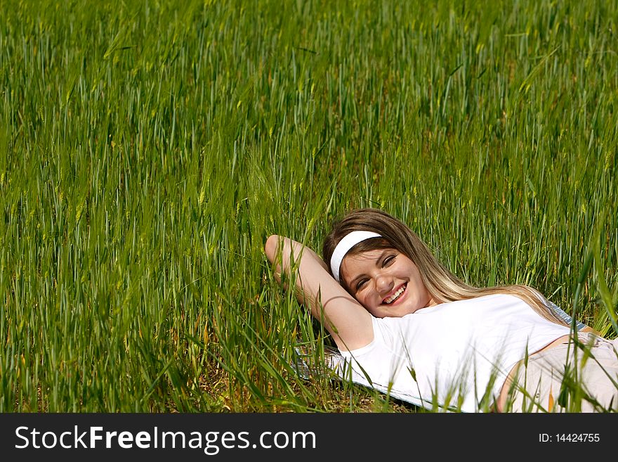 Happy girl laying in green grass