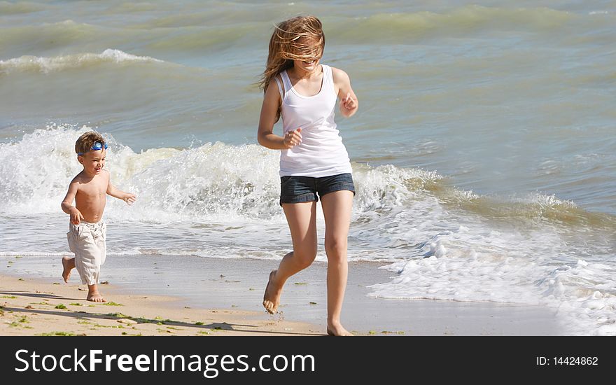 Mother And Son Running On Beach