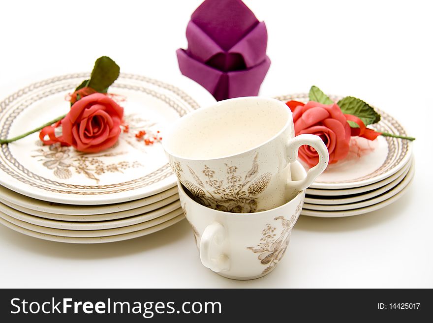 Plates and cups with roses and napkins. Plates and cups with roses and napkins